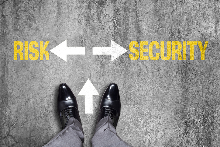 Low section view of a businessman standing by text Risk or Security with opposite arrow signs.