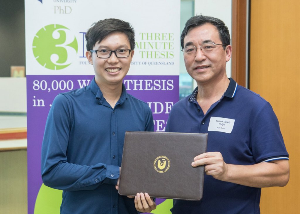 Andree receiving the SMU Presidential Doctoral Fellowship from Professor Robert Deng, SMU’s Dean of Postgraduate Research Programmes.